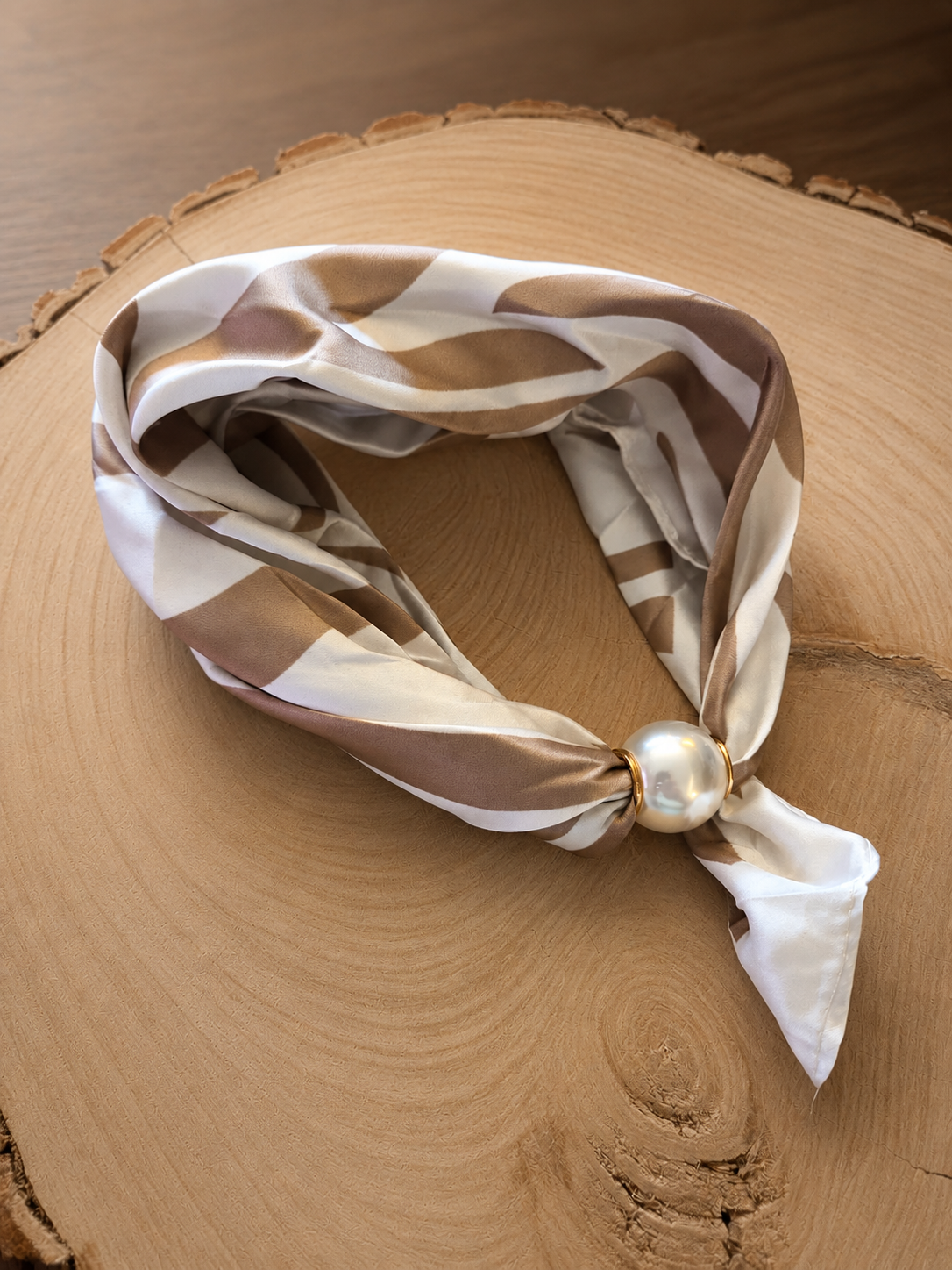 Beige magneet sjaaltje met abstracte print en pareldetail