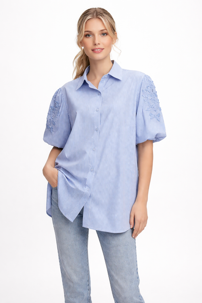Lichtblauwe gestreepte blouse met geborduurde mouwen
