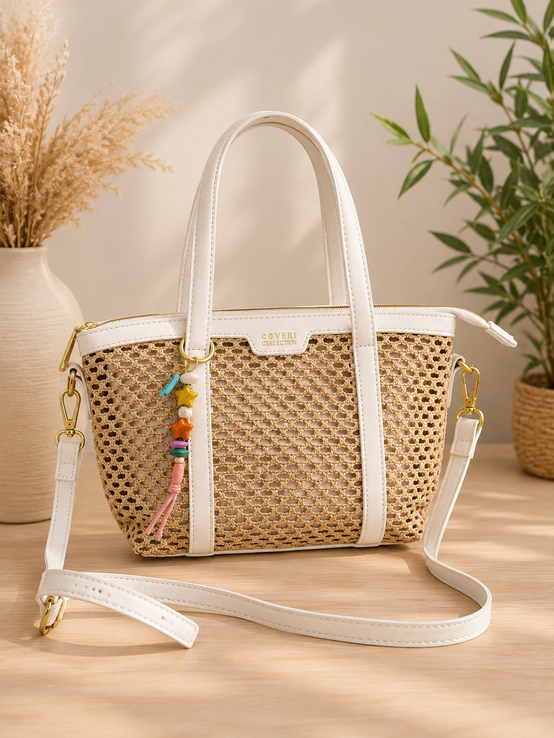 Ontdek deze beige handtas met gevlochten look, witte details en bedelhanger. Een stijlvolle tas met schouderband voor dagelijks gebruik.