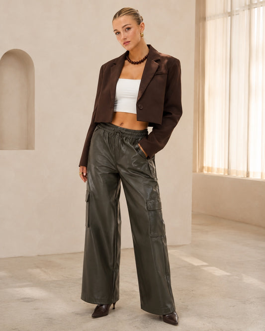 Model draagt olijfgroene PU-lederen Cargo Broek Amara met wide-leg pasvorm
