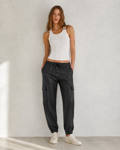 Model draagt zwarte lederlook Cargo Broek Nova met elastische taille en cargozakken