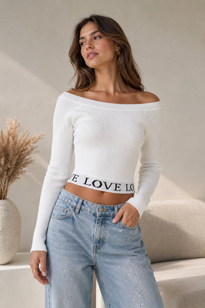 Model draagt offwhite Croptop Trui Noa met boothals en LOVE-boord