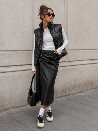 Model draagt zwarte lederlook Rok Celeste met zijsplit en goudkleurige knopen