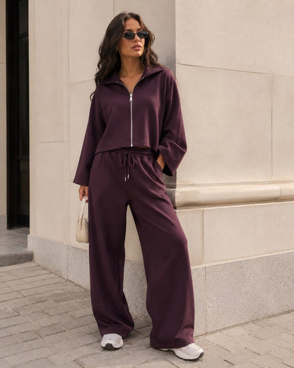 Model draagt aubergine dames set met vest en wijde broek