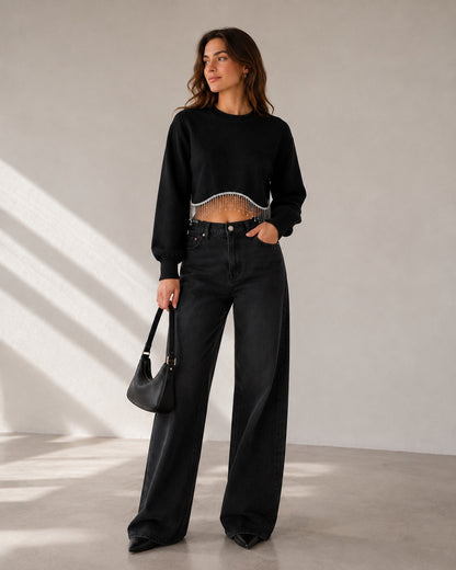 Model draagt zwarte cropped Trui Liora met zilverkleurige kristallen franjes